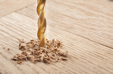 metal drill bit make holes in the wooden oaks plank