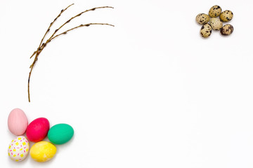 Easter eggs and willow twigs on white background