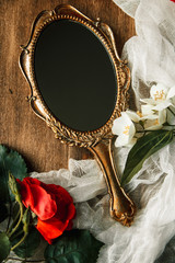 Beautiful a vintage mirror with flowers on wooden background