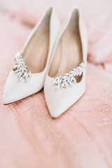 Fototapeta na wymiar Bride's shoes for the wedding day on bed sheet
