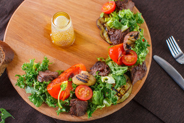 Salad leaves with sliced roast beef and sun-dried cherry tomatoes