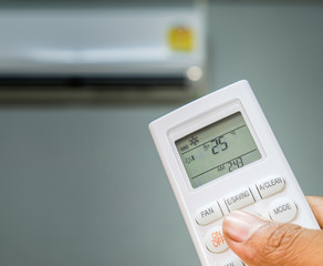 hand holding air  conditioner remote