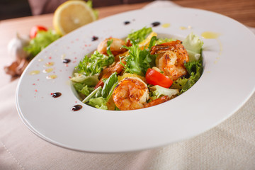 Caesar salad with shrimps and iceberg leaves