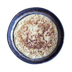 hot pancake on an old cast-iron frying pan isolated on white background, top view