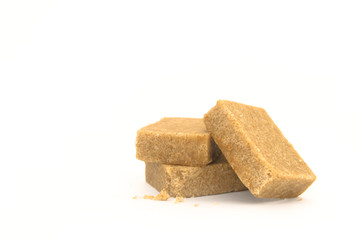 Three pieces of chicken stock cubes with some crumbs arranged on a white background