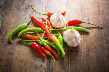 Red and green chili and garlic on an old wooden background