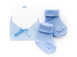 Small boy blue socks, blank card in evelop on white background. Flat lay.