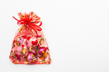 Chocolate heart-shaped in red bag on white background