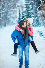Fototapeta na wymiar woman and man having fun in winter forest