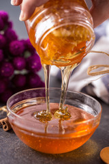 Fresh honey dripping in bowl .