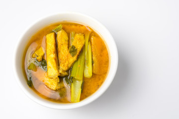 Sour soup made of tamarind paste with chinese cabbage and pork grilled in bowl on white background