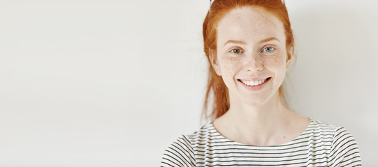 Heterochromia concept. Attractive young woman with ginger hair and different colored eyes smiling...