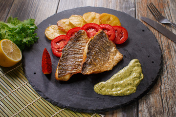 dorado fish with potatoes and tomatoes