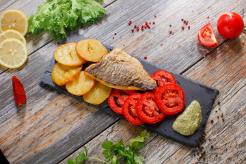 dorado fish with potatoes and tomatoes