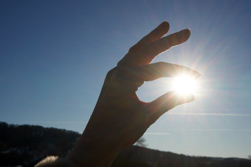 Fototapeta na wymiar Silhouette Hand fasst Sonne