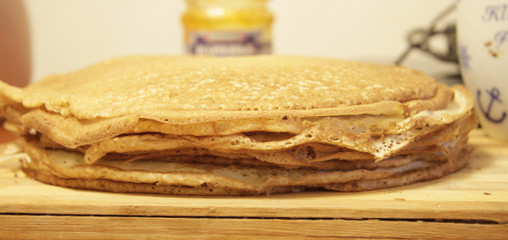 Stack of homemade pancakes on wood cooking board