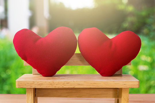 picture of two red heart pillow on the wooden chair, garden background, Valentine Day, card