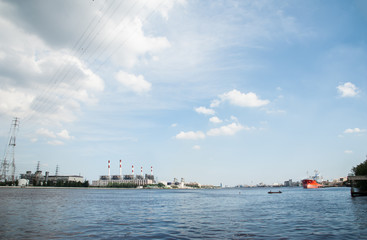 The panoramic view of the electric refinery plant and big red logistic ship in Chao Praya river, Bangkok.
