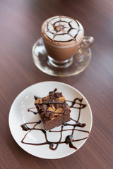 Brownies with chocolate sauce topping on white plate