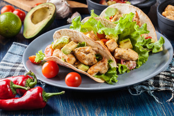 Authentic mexican tacos with chicken and salsa with avocado, tomatoes and chillies