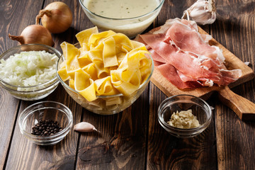Ingredients ready for preparing pappardelle with prosciutto and cheese sauce