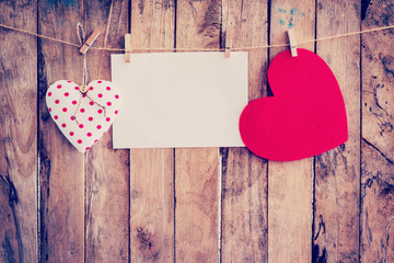 Two heart hanging and paper on clothesline and rope with wooden
