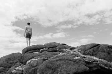 Man Looking Ocean Beach Rocks Sky