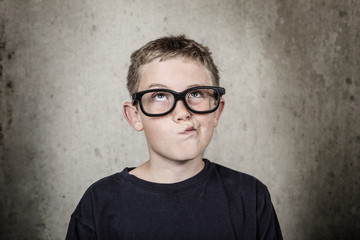 Boy wearing glasses, thinking.