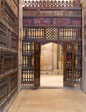 Interleaved wooden wall (mashrabiya) with wooden ornate door in Sultan Qalawun mosque, a historic mosque in Old Cairo, Egypt