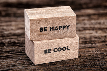 Be happy and be cool text on  wooden cubes on  wood background
