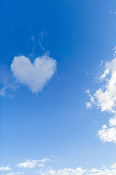 Sunny blue day with a heart shape cloud.
