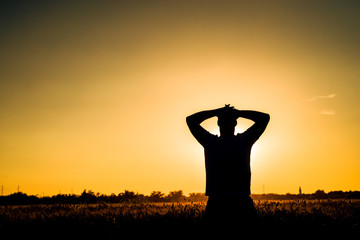 Silhouette of man enjoying in the beautiful sunset view.
