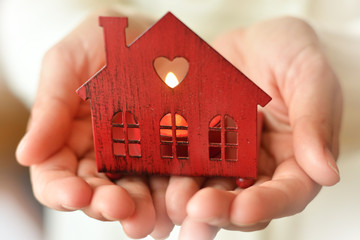 Warm and cozy miniature house in female hands. Care and love.