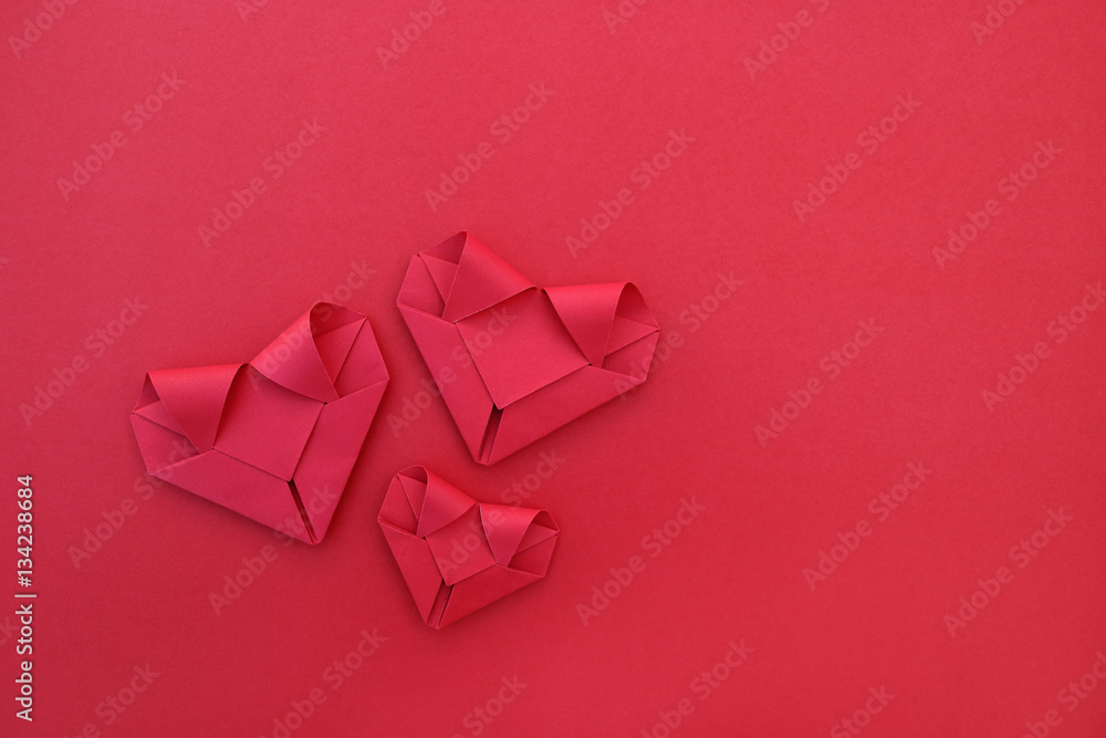 Poster three folding red paper hearts on red for pattern and background