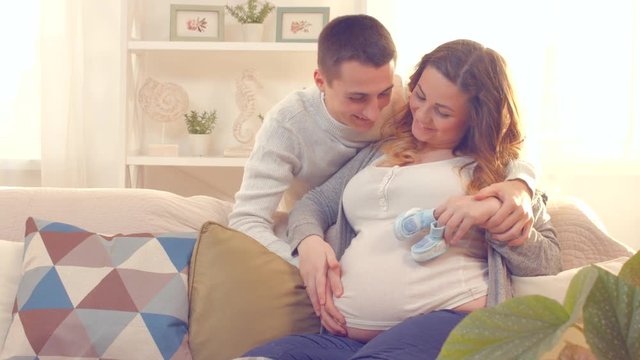 Happy young couple expecting baby. Beautiful pregnant woman and her husband together. 4K UHD video. Ultra high definition 3840X2160