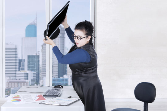 Stressful woman throwing computer