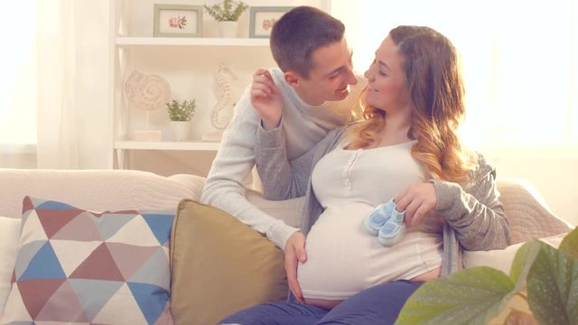 Happy young couple expecting baby. Beautiful pregnant woman and her husband together. 4K UHD video. Ultra high definition 3840X2160