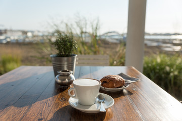 Breakfast of cappuccino and pastry at the beach