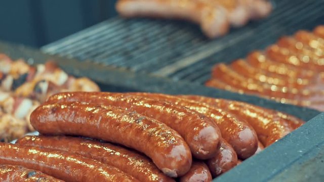 Barbecue large grill outdoors. Cookout bbq food. Big roasted pork bratwurst german sausages, white polish kielbasa. Meat grilled meal. Street food, fast food. Slow motion.