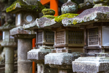 Rows of ancient stone and wooden lanterns Toro covered in moss in Nara