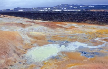 Schwefelquelle und Rinnsal am Leirhnjúkur / Leirhnjukur - Vulkan, im Hintergrund frisches Lavafeld und Berge mit Schneefeldern, Norðurland eystra, Island 