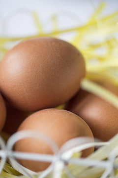 Osterdekoration - Braune Eier in einem Drahtkoerbchen