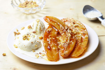 Caramelized Bananas, Ice-cream and Chopped Nuts Dessert on a plate