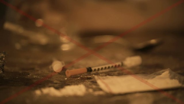 Table covered with used syringes and drug powder, addicted person needs help