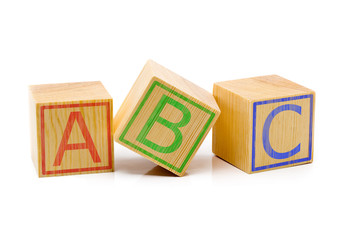 ABC letters on three brown wooden cubes lined up