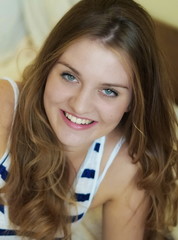 portrait of a young beautiful smiling girl with green eyes and long blond hair 	
