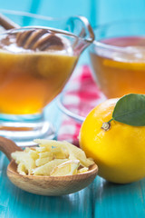 Ginger, lemon and honey bowl on wooden table. Rustic wooden background.