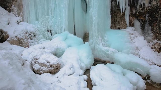 Panning fottage of a waterfall in the winter with icicles