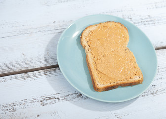 Bread with peanut butter on wooden background