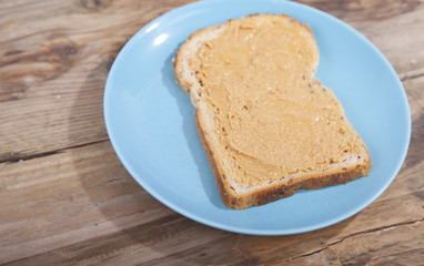 Fototapeta na wymiar Bread with peanut butter on wooden background